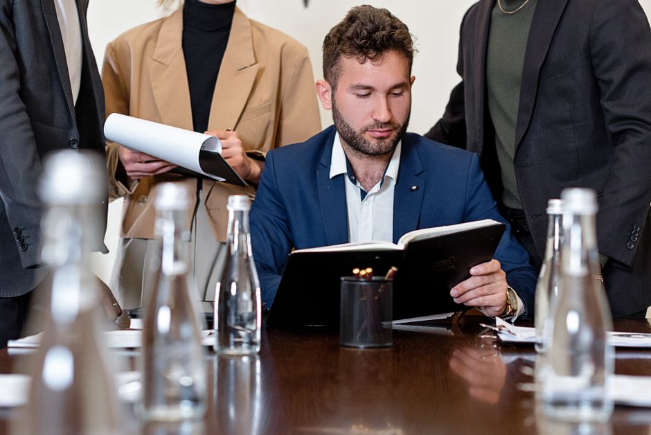 A professional team in business attire reviewing documents during a meeting.
